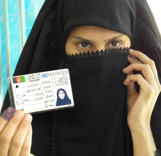 Una dona ensenya la tarja de votant després d'exercir el seu dret a un col·legi de Kandahar.